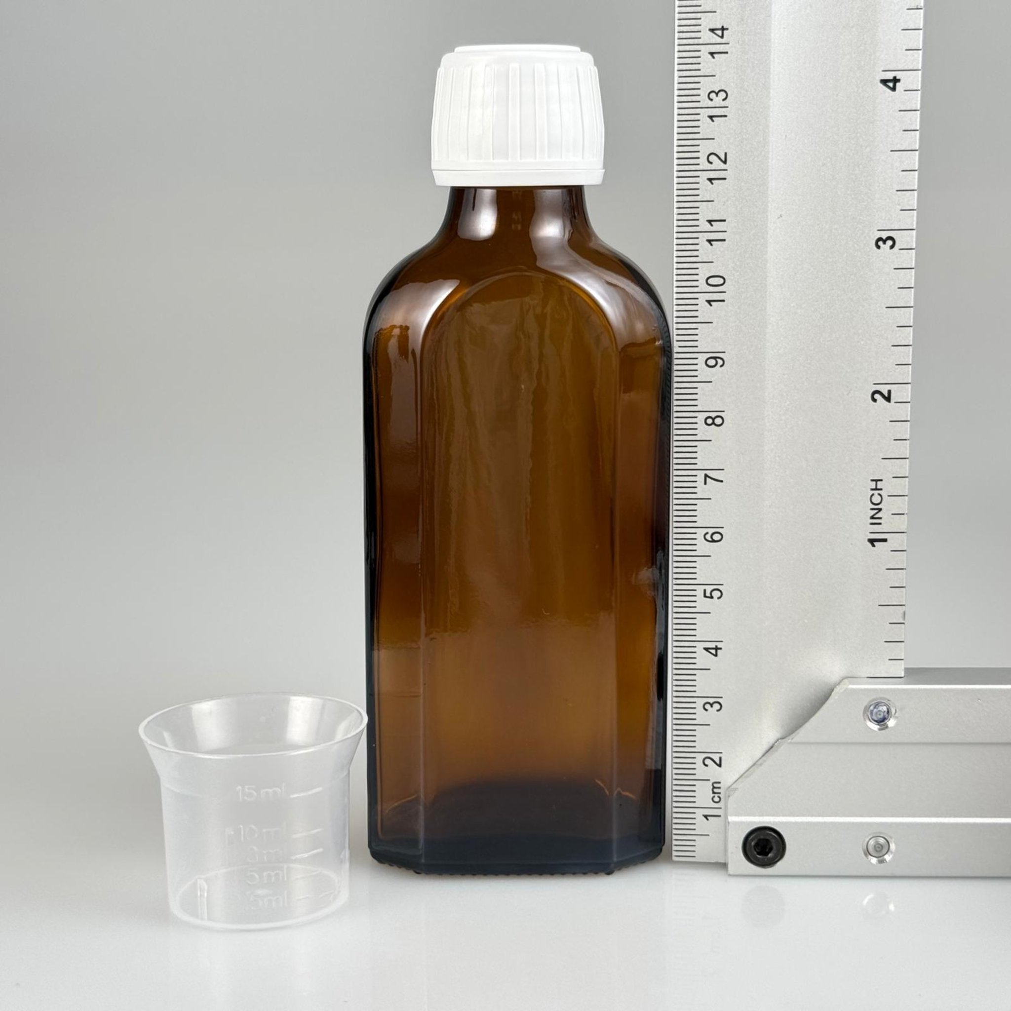 100 CC AMBER YASSI CAM ŞİŞE + BEYAZ KİLİTLİ ECZA KAPAK + 15 ML ÖLÇEK TAKIM 100 ML KAHVERENGİ YASSI MODEL CAM ŞİŞE
