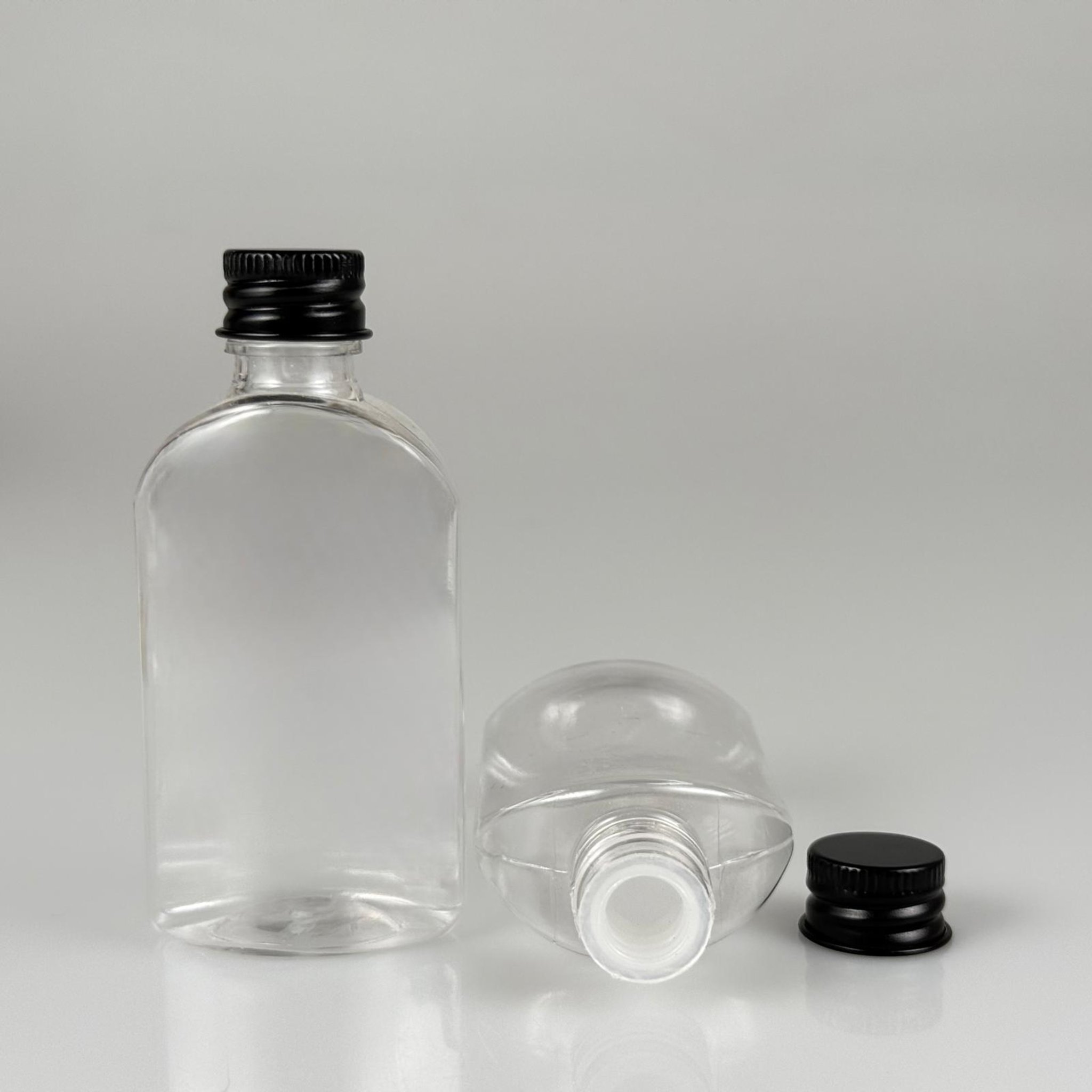 50 CC ŞEFFAF YASSI OVAL MODEL PET ŞİŞE + KÖPÜK CONTALI SİYAH ALÜMİNYUM METAL KAPAKLI + KÖR TIPALI TAKIM - 50 ML PLASTİK ŞİŞE