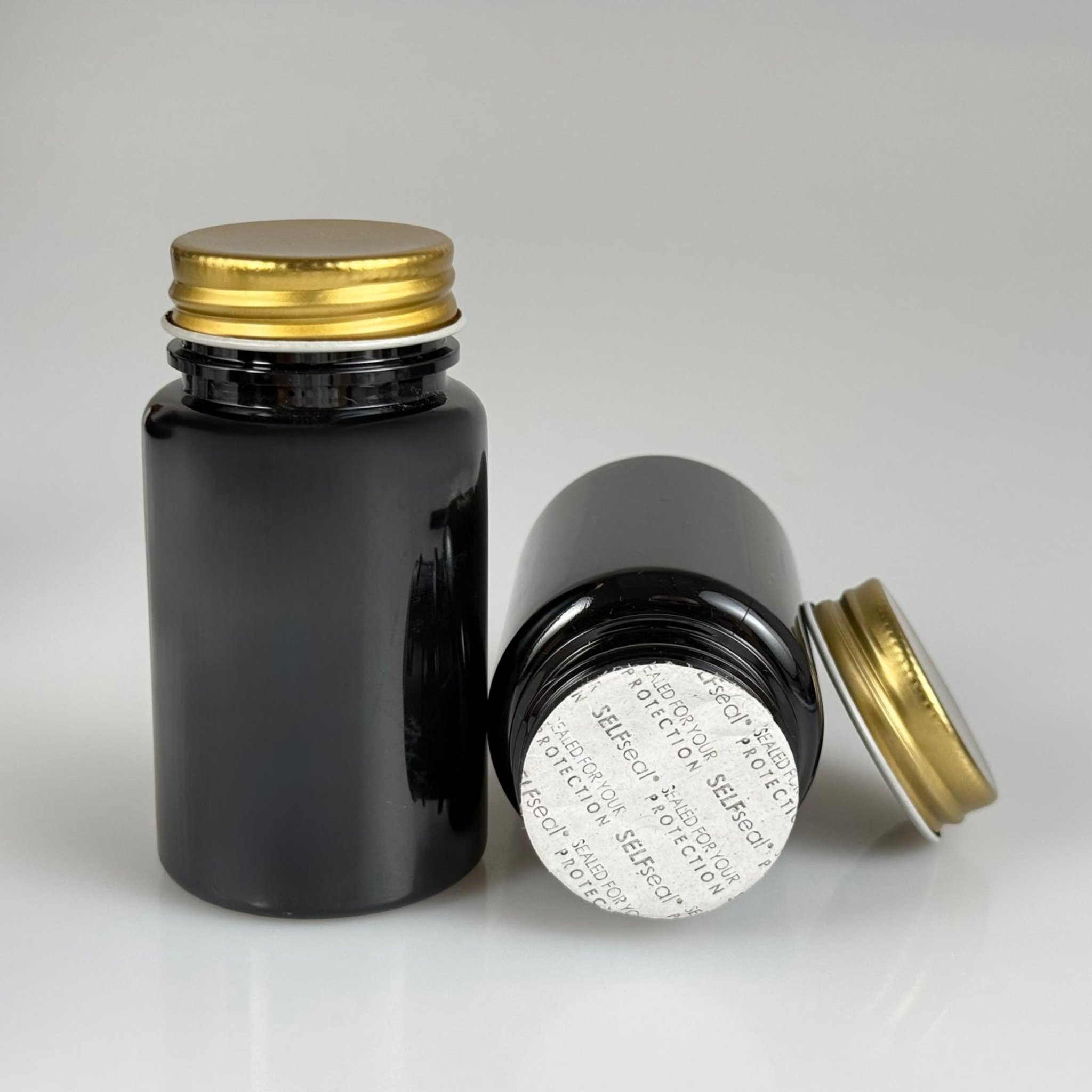 100 CC SİYAH PET TABLET ŞİŞESİ - GOLD METAL KAPAKLI + KENDİNDEN YAPIŞKANLI KÖPÜK CONTALI - 100 ML KAPSÜL KUTUSU - İLAÇ ŞİŞESİ - MEDİKAL HAP ŞİŞESİ - FARMASÖTİK KAVANOZ