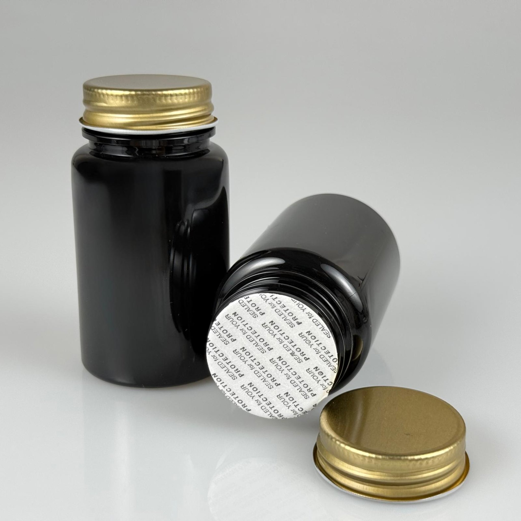 100 CC SİYAH PET TABLET ŞİŞESİ - GOLD METAL KAPAKLI + KENDİNDEN YAPIŞKANLI KÖPÜK CONTALI - 100 ML KAPSÜL KUTUSU - İLAÇ ŞİŞESİ - MEDİKAL HAP ŞİŞESİ - FARMASÖTİK KAVANOZ