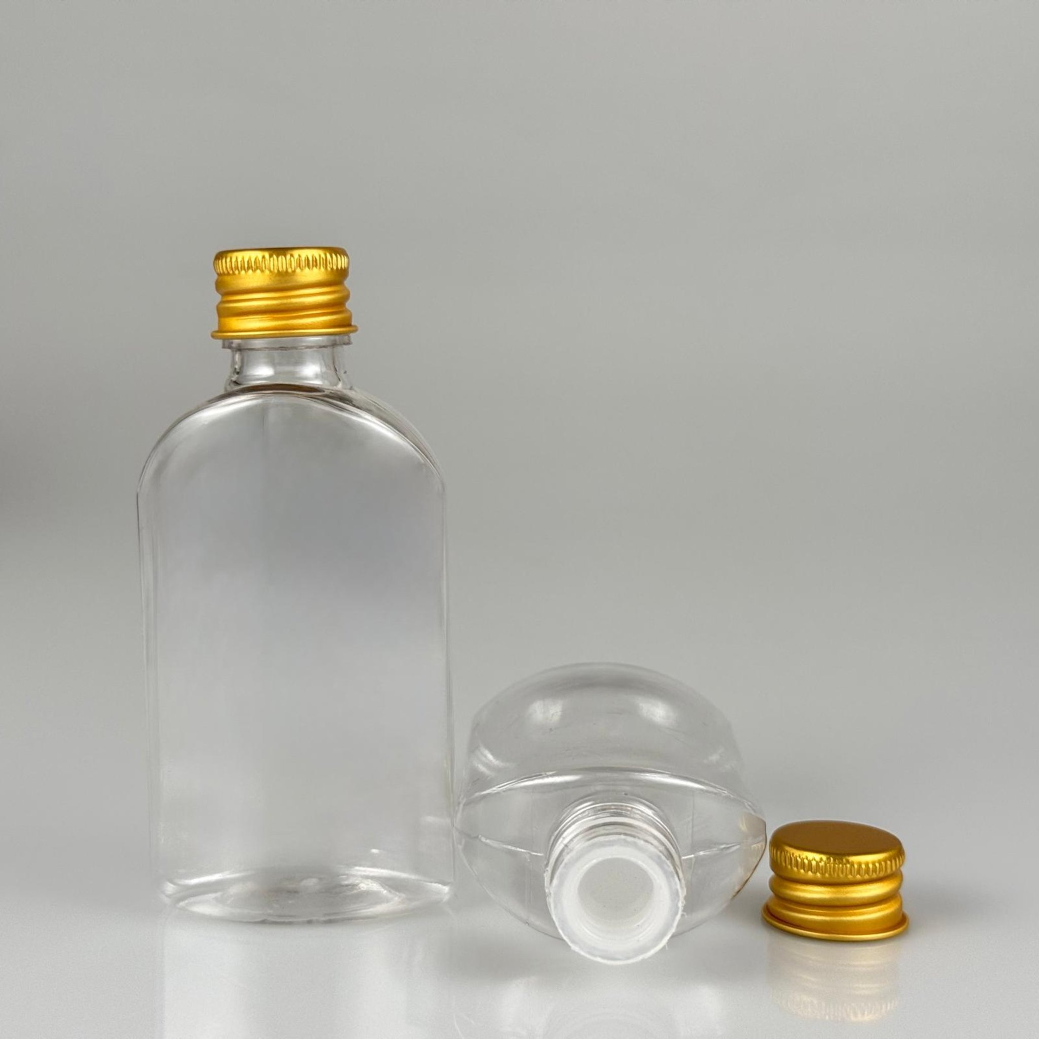50 CC ŞEFFAF YASSI OVAL MODEL PET ŞİŞE + KÖPÜK CONTALI GOLD ALÜMİNYUM METAL KAPAKLI + KÖR TIPALI TAKIM - 50 ML PLASTİK ŞİŞE