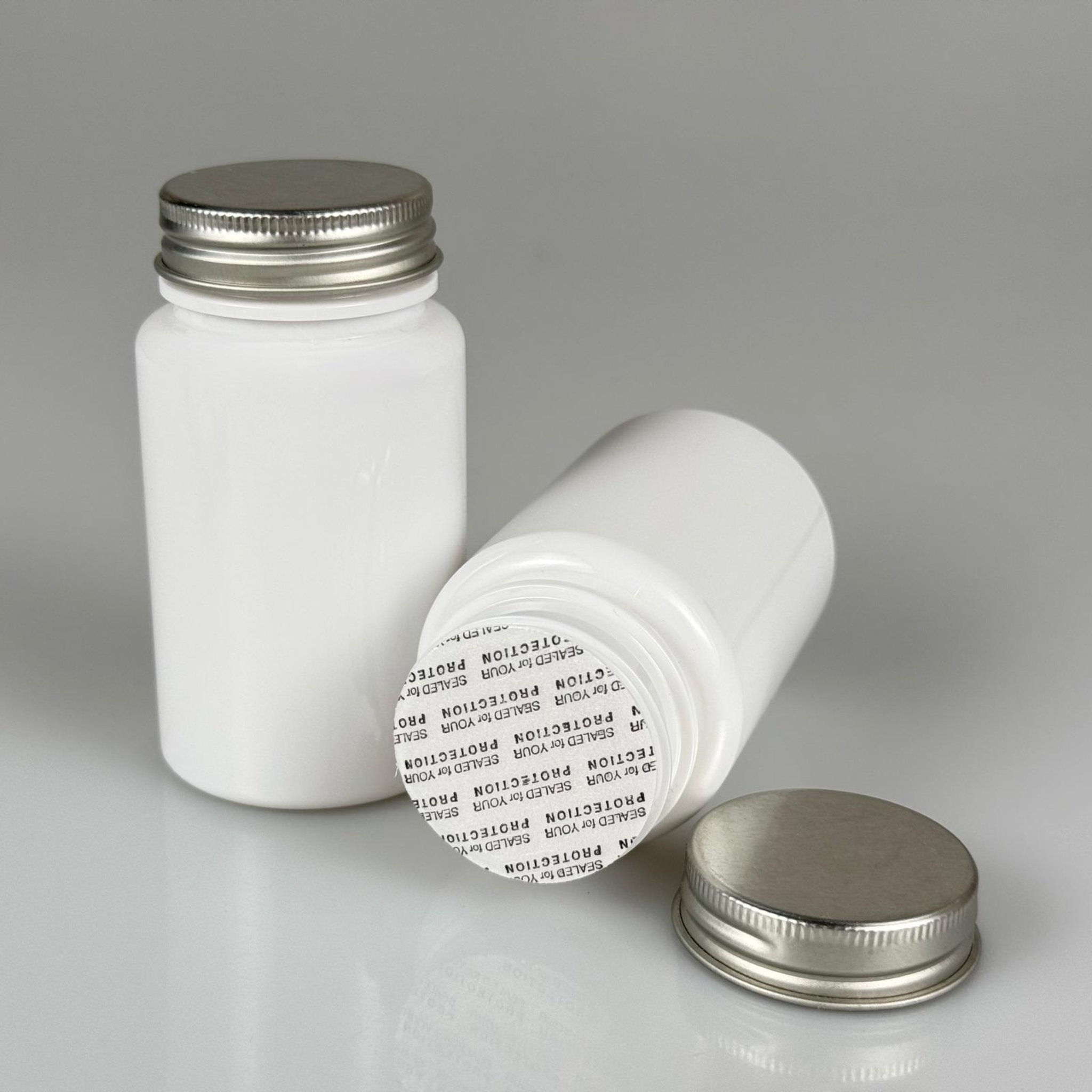 100 CC BEYAZ PET TABLET ŞİŞESİ - GÜMÜŞ METAL KAPAKLI + KENDİNDEN YAPIŞKANLI KÖPÜK CONTALI - 100 ML KAPSÜL KUTUSU - İLAÇ ŞİŞESİ - MEDİKAL HAP ŞİŞESİ - FARMASÖTİK KAVANOZ